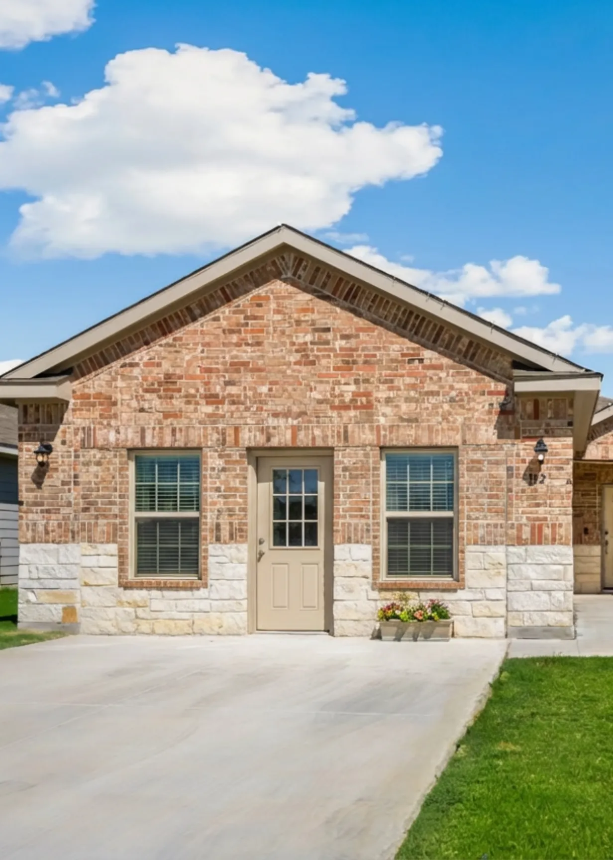 Rear view of a completed, craftsman-style Accessory Dwelling Unit (ADU) in Los Angeles by ADU Especialista LA, featuring yellow siding, a spacious patio with furniture, and decorative wrought-iron pillars.