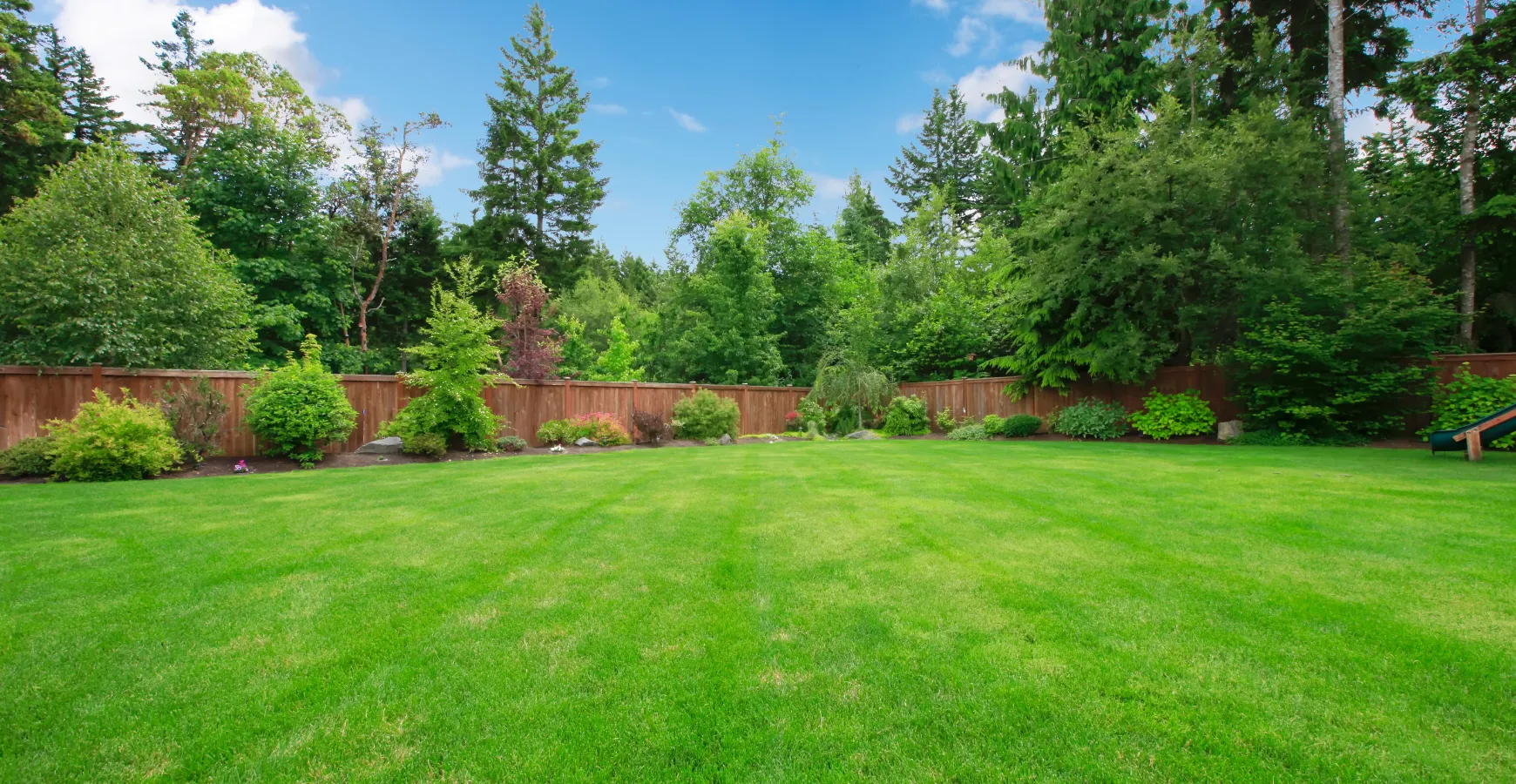 Empty backyard in Los Angeles before prefab ADU installation showing open lawn ready for modular unit placement